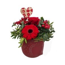 Flower arrangement in red ceramic pot with hearts