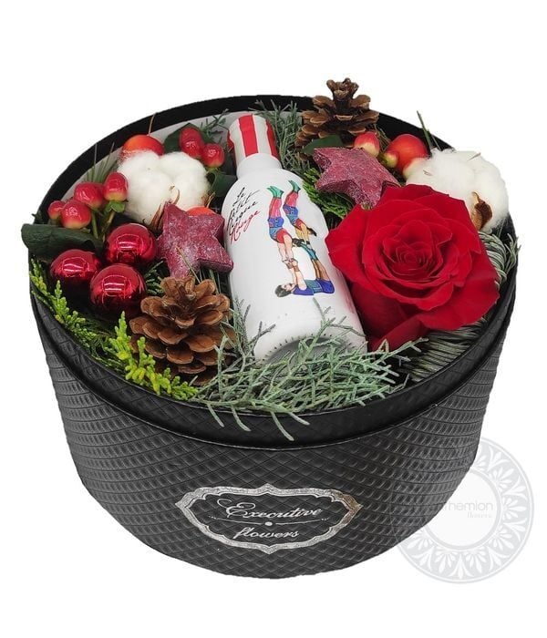 Gift box with xmas decoration and a small bottle of wine