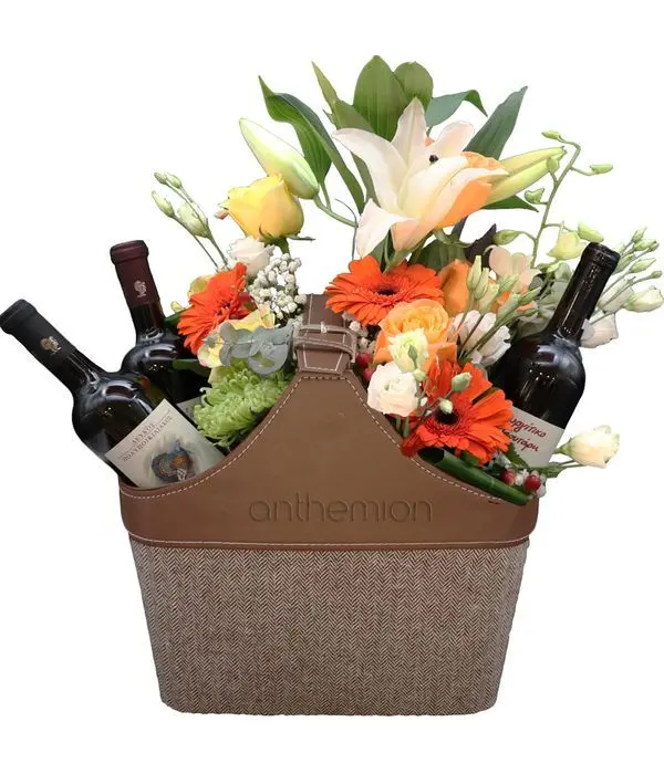 Brown leather case with three bottles of wine and flowers