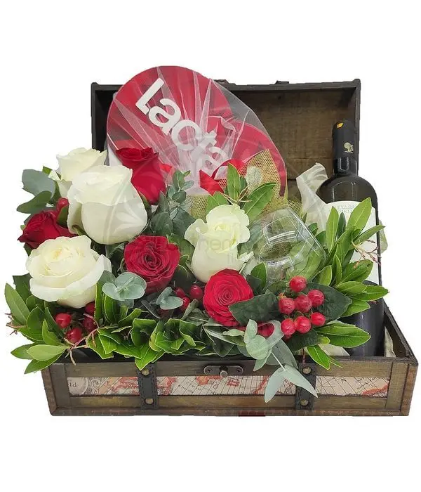 Wooden chest with wine, two wine glasses and chocolate