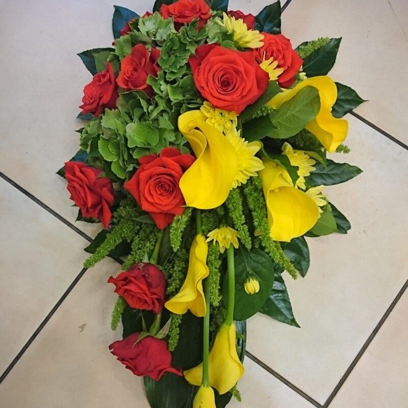 Funeral arrangement with red and yellow flowers