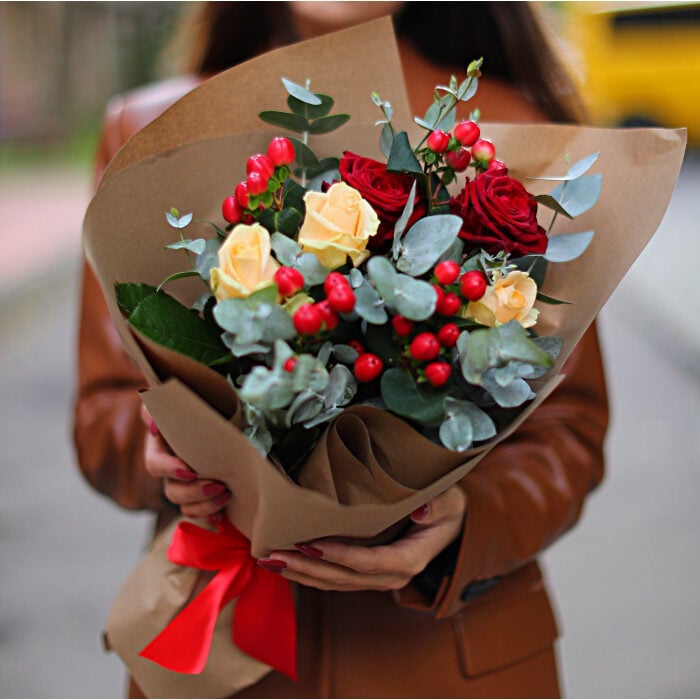 Boquet of red and cream roses with Hippericum