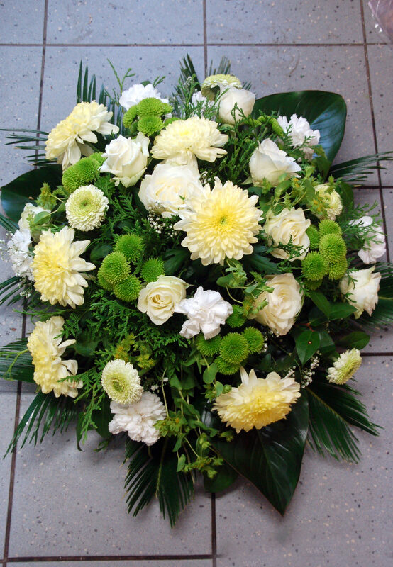 Round-shaped funeral arrangements in creamy, white and green tones