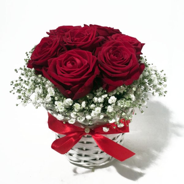 Arrangement of red roses in small white basket
