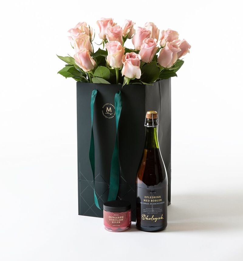 Pink roses in a gift bag with bubbles and chocolate