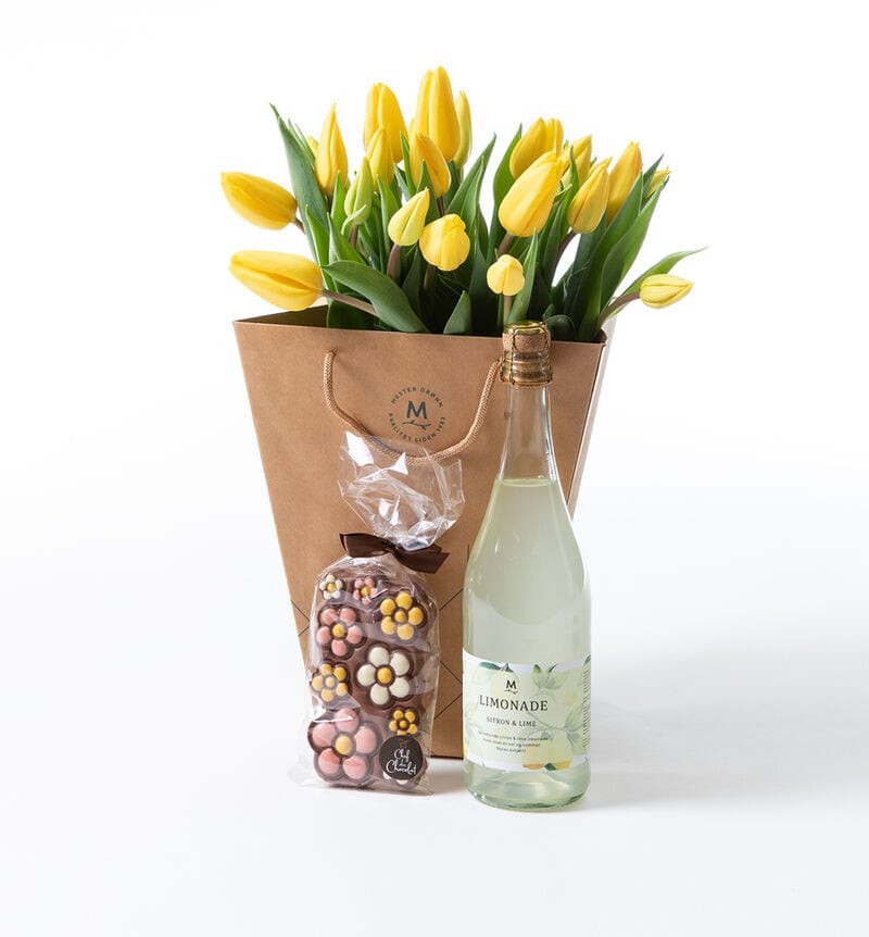 Yellow tulip bouquet in gift bag with chocolate