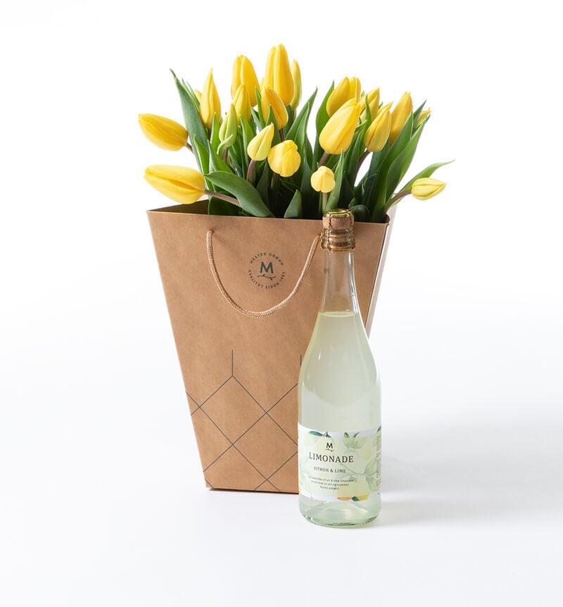Yellow tulip bouquet in gift bag with drink