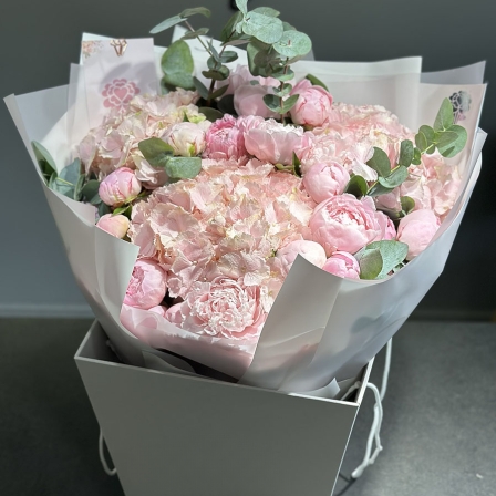 A bouquet of peonies and hydrangeas in a designer design in a box